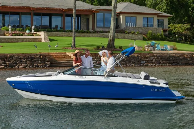 Slide: The Image of Manufacturer Provided Image: 2022 Cobalt R4 boat on water with people enjoying near a lakeside house. - 12