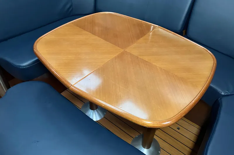Slide: The Image of Wooden table with blue cushioned seating in a 2005 Beneteau Oceanis 423 yacht interior. - 5