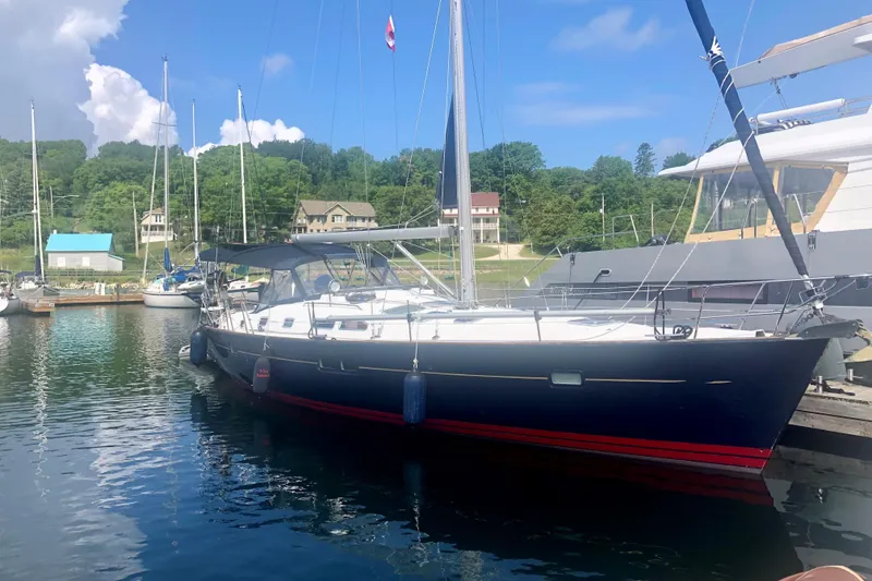 The Image of 2005 Beneteau Oceanis 423 sailboat docked in a scenic marina setting. - 0