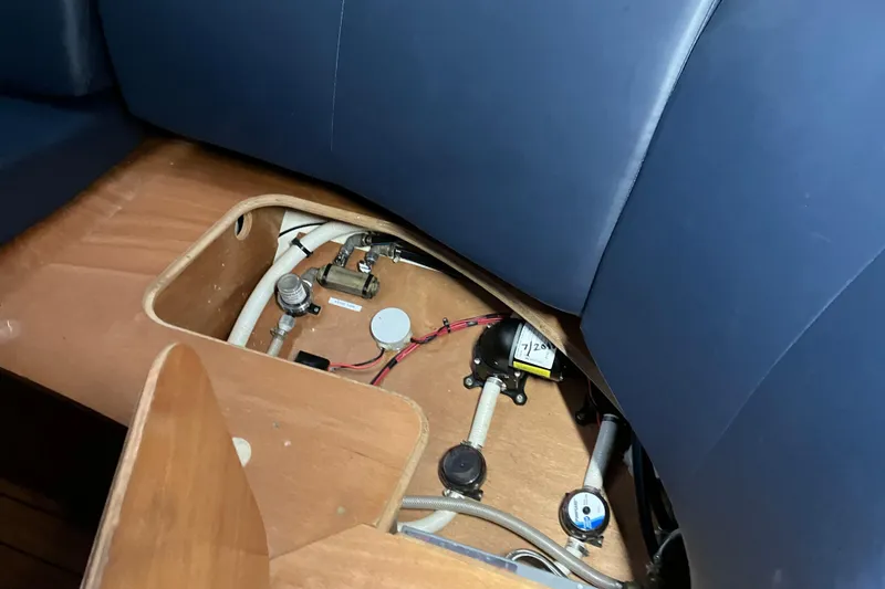 Slide: The Image of Beneteau Oceanis 423 (2005) interior showing under-seat storage with visible plumbing components. - 37