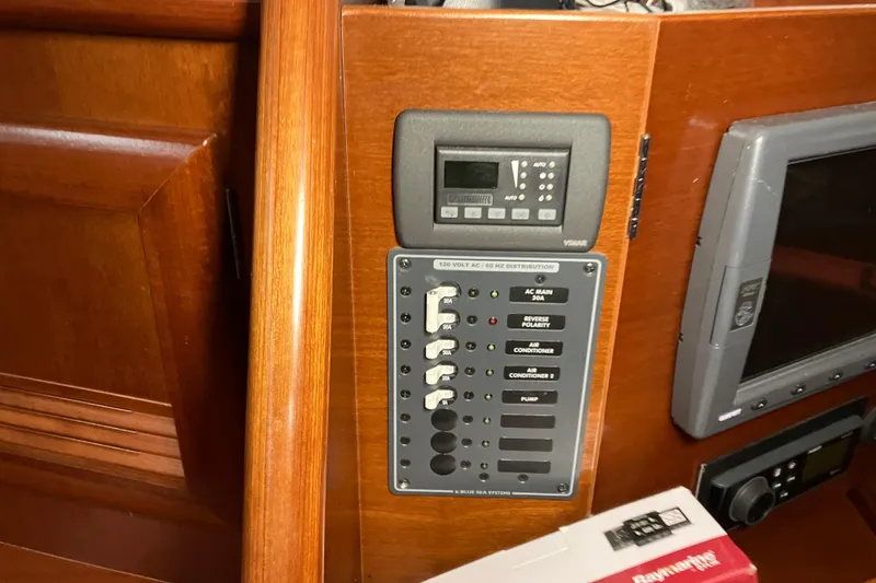Slide: The Image of Control panel on a 2005 Beneteau Oceanis 423 sailboat, featuring electrical switches and displays. - 20