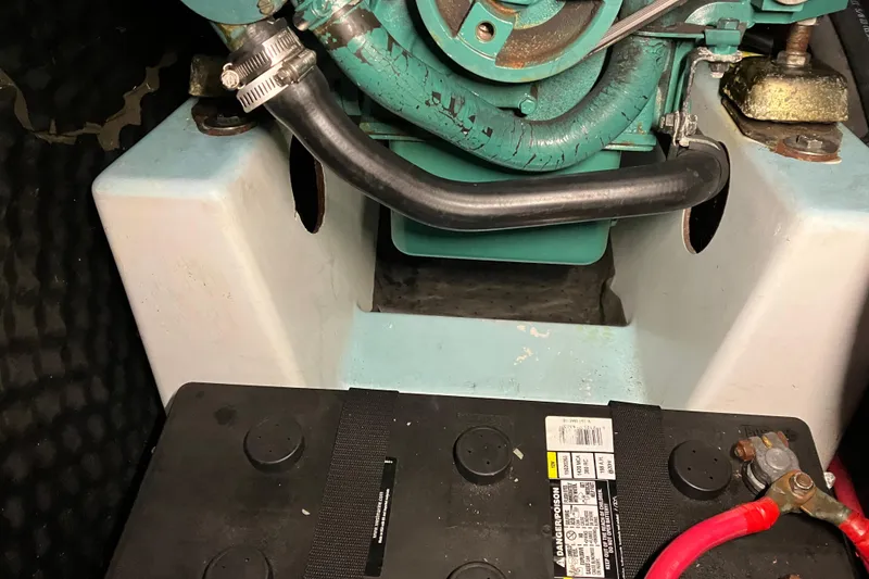 Slide: The Image of Engine compartment of a 2005 Beneteau Oceanis 423 sailboat, featuring battery and hoses. - 31