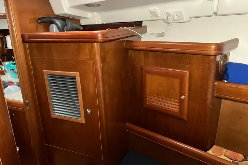 Slide: The Image of Interior of 2005 Beneteau Oceanis 423 yacht with wooden cabinetry and storage compartments. - 15