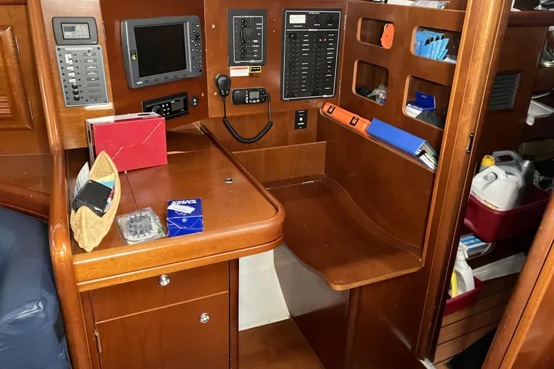 Slide: The Image of Navigation station of a 2005 Beneteau Oceanis 423 sailboat with control panels and storage. - 19