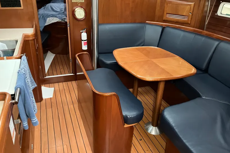 Slide: The Image of Interior of 2005 Beneteau Oceanis 423 yacht with wooden table and blue seating. - 3