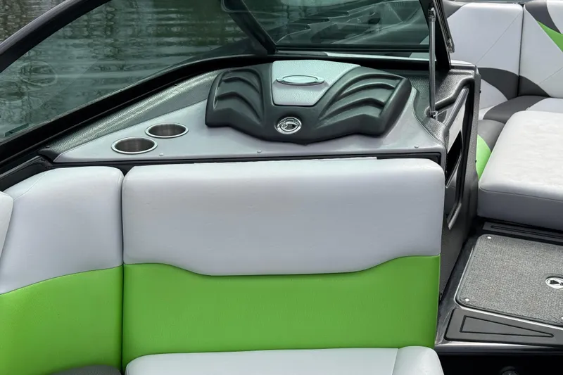 Slide: The Image of 2015 Centurion Enzo FS44 boat interior with green and gray seating, cup holders, and sleek design. - 21
