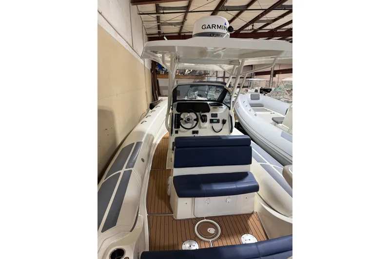 Slide: The Image of 2023 Brig Eagle 8 boat interior with Garmin equipment, featuring blue seating and wooden flooring. - 3
