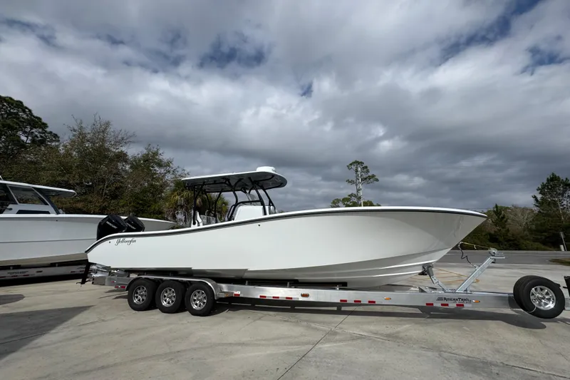 Slide: The Image of 2026 Yellowfin 34 Offshore boat on trailer, parked outdoors under cloudy sky. - 10