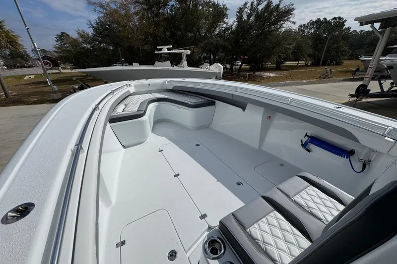 Slide: The Image of 2026 Yellowfin 34 Offshore boat interior with seating and storage, docked outdoors. - 22