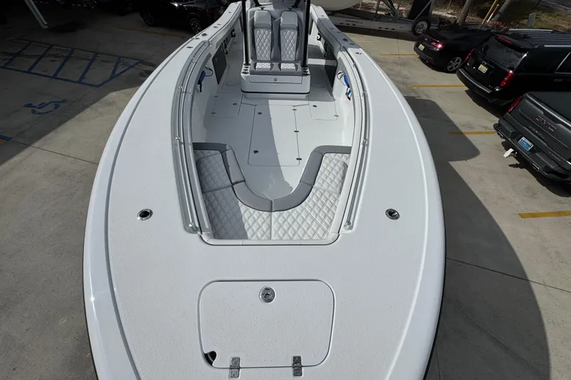 Slide: The Image of 2026 Yellowfin 34 Offshore boat with spacious deck and seating, parked in a lot. - 23