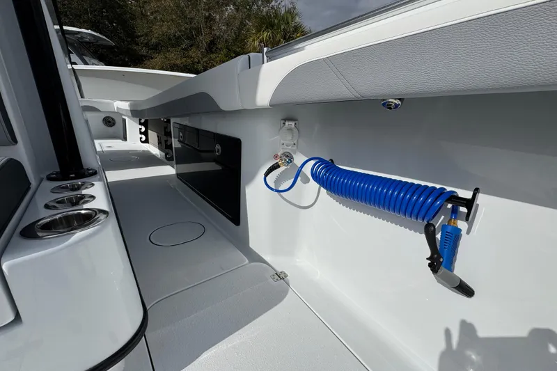 Slide: The Image of 2026 Yellowfin 34 Offshore boat interior with coiled hose and cup holders. - 28