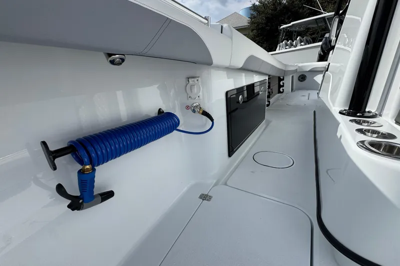 Slide: The Image of 2026 Yellowfin 34 Offshore boat interior with coiled hose and storage compartments. - 29
