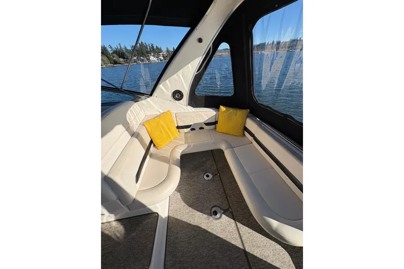 Slide: The Image of 2001 Chaparral Signature 300 boat interior with seating and cup holders, docked by the water. - 18