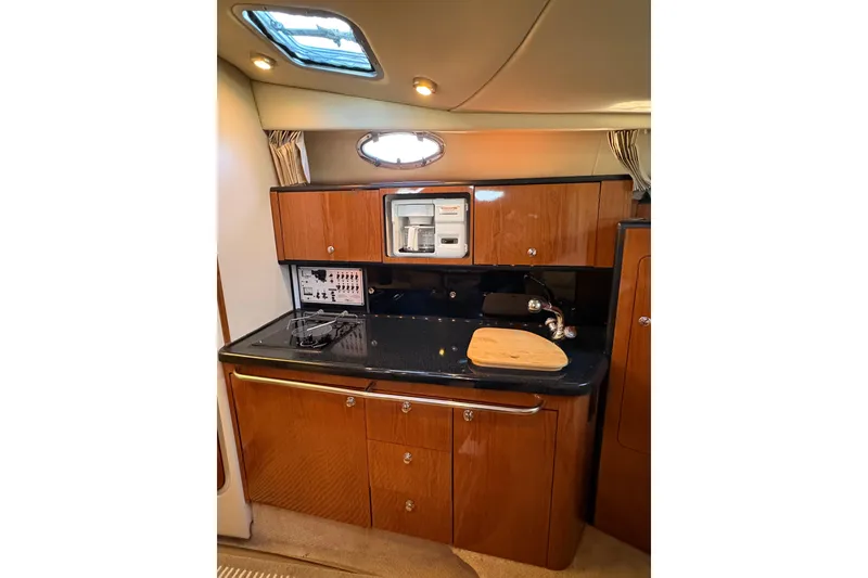 Slide: The Image of Interior of 2001 Chaparral Signature 300 boat with kitchenette and wood cabinetry. - 27