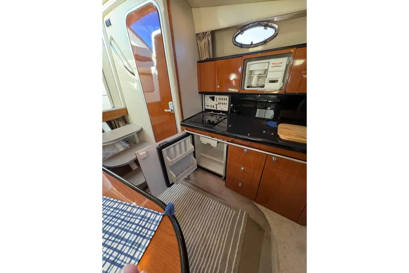 Slide: The Image of 2001 Chaparral Signature 300 yacht kitchen with wood cabinets and modern appliances. - 28