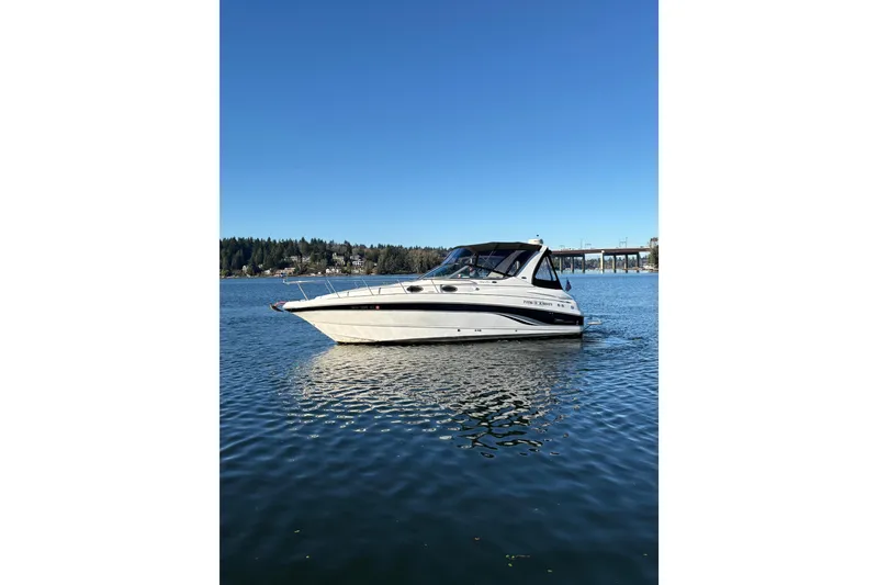 Slide: The Image of 2001 Chaparral Signature 300 boat on calm water with bridge and trees in background. - 3