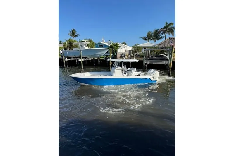The Image of 2023 Contender 28 Tournament boat on water, surrounded by palm trees and docks. - 0