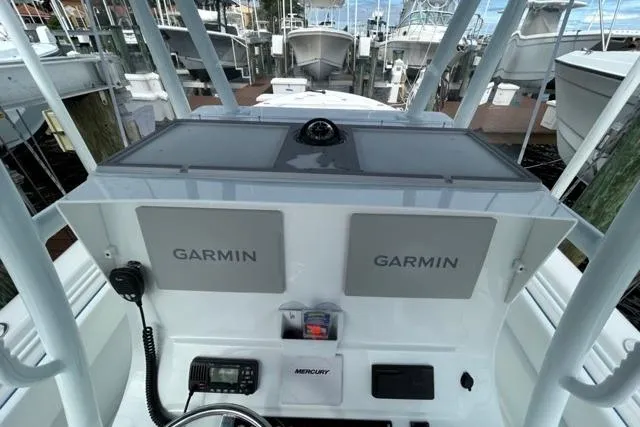 Slide: The Image of 2023 Contender 28 Tournament boat dashboard with Garmin navigation systems at a marina. - 14