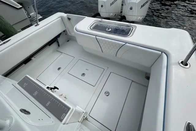 Slide: The Image of 2023 Contender 28 Tournament boat deck with storage compartments and dual Mercury engines. - 17