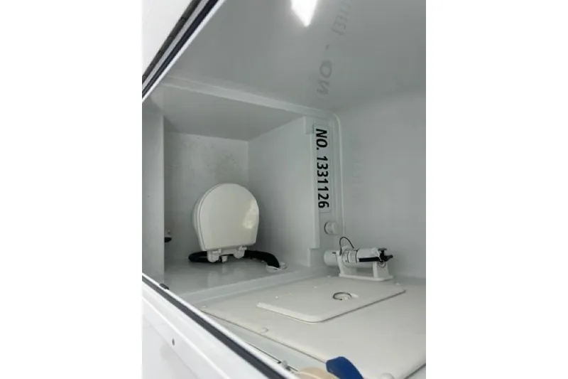 Slide: The Image of Interior of 2023 Contender 28 Tournament boat, featuring a compact marine toilet. - 26