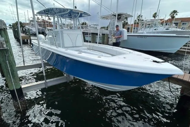 Slide: The Image of 2023 Contender 28 Tournament boat in marina, blue and white hull, docked. - 27