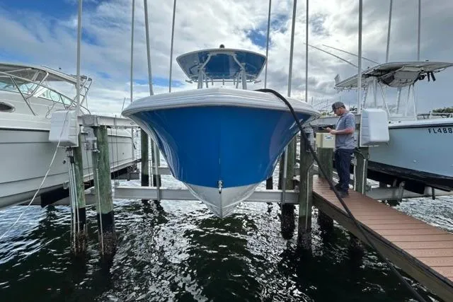Slide: The Image of 2023 Contender 28 Tournament boat docked, with a person performing maintenance. - 30