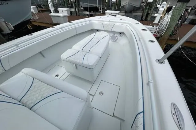 Slide: The Image of 2023 Contender 28 Tournament boat interior with white cushioned seating and storage compartments. - 7