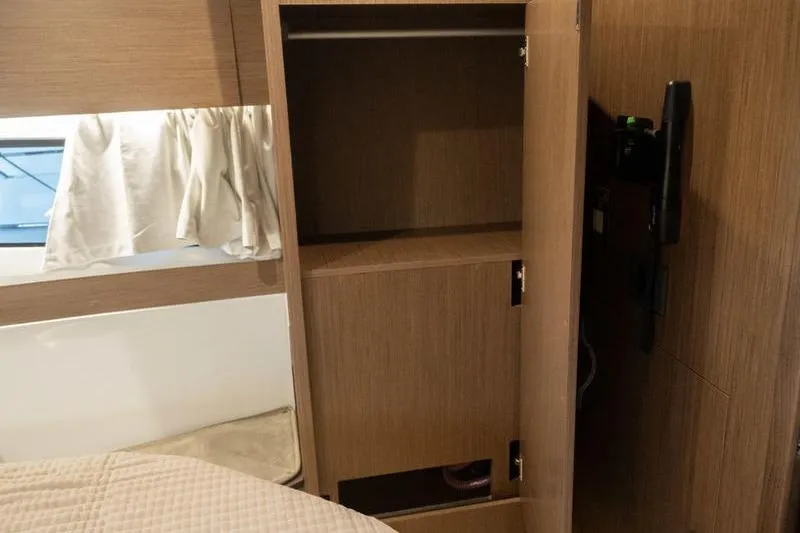 Slide: The Image of 2026 Beneteau Antares 11 Fly interior cabin with open wooden storage cabinet. - 32