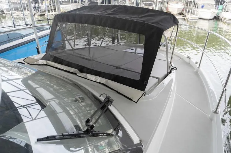 Slide: The Image of 2026 Beneteau Antares 11 Fly boat with covered deck, docked in marina. - 35