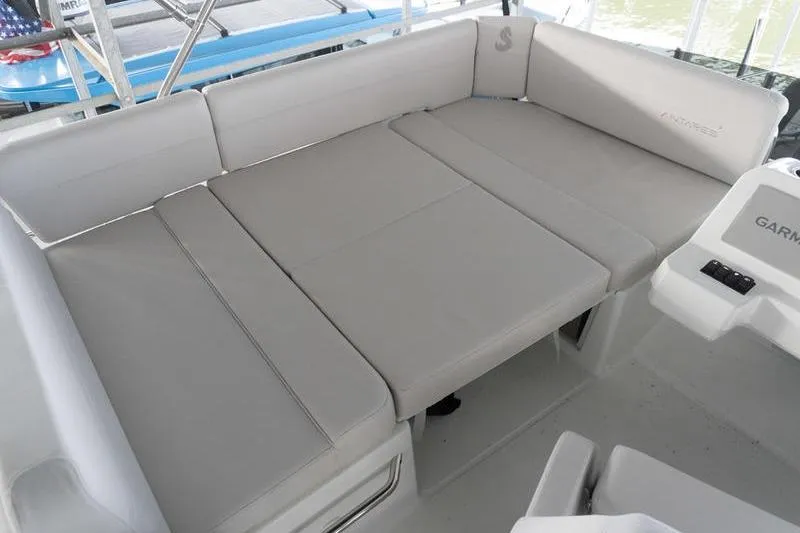 Slide: The Image of 2026 Beneteau Antares 11 Fly boat interior with beige cushioned seating area. - 42