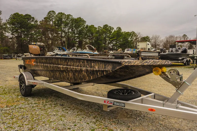 Slide: The Image of 2026 Excel 1751 Shallow Water F4 boat on trailer, camo design, outdoor setting. - 5