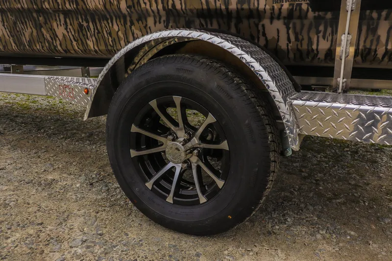 Slide: The Image of 2026 Excel 1751 Shallow Water F4 trailer wheel with diamond plate fender on gravel. - 9