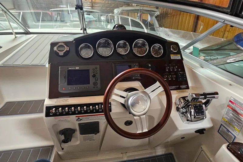 Slide: The Image of Cockpit of 2010 Sea Ray Sundancer 310 with steering wheel and control panel. - 14