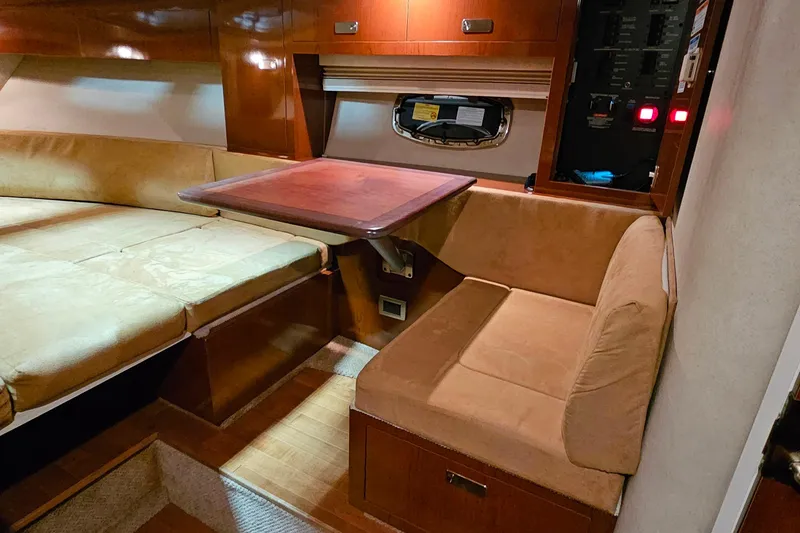 Slide: The Image of 2010 Sea Ray Sundancer 310 interior with cozy seating and wooden table. - 18