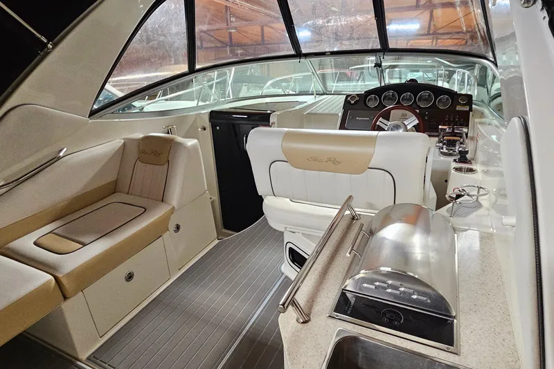 Slide: The Image of 2010 Sea Ray Sundancer 310 interior with helm, seating, and kitchenette. - 4