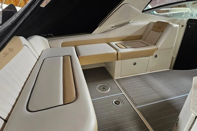 Slide: The Image of Interior of 2010 Sea Ray Sundancer 310, featuring beige and white seating with storage compartments. - 5