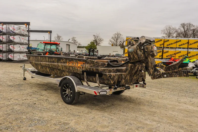 Slide: The Image of Camouflage-patterned 2026 Excel 1751 F4 Pro boat on a trailer in an outdoor lot. - 2