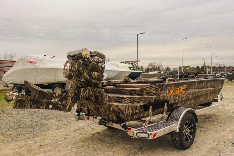 Slide: The Image of 2026 Excel 1751 F4 Pro boat with camouflage design on a trailer in a parking lot. - 4