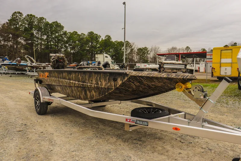 Slide: The Image of 2026 Excel 1751 F4 Pro boat on trailer, camo design, parked outdoors. - 6