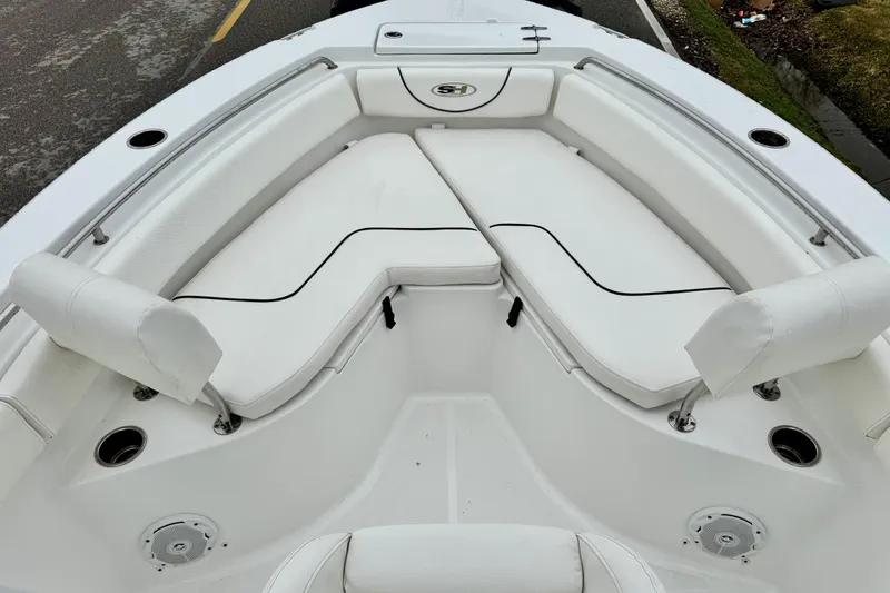 Slide: The Image of 2016 Sea Hunt Ultra 211 boat interior with white cushioned seating and cup holders. - 14