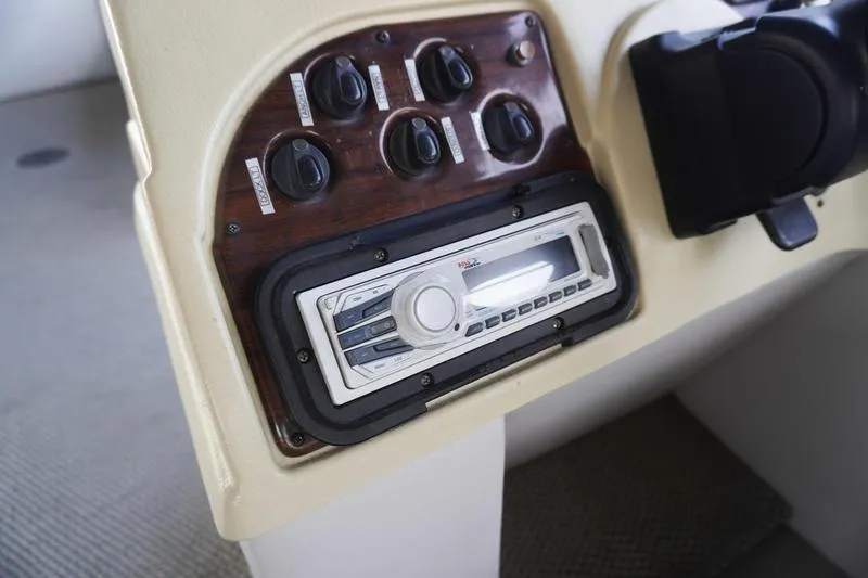 Slide: The Image of Control panel of a 2000 Sundancer Pontoons 240 Majestic with stereo system and switches. - 20