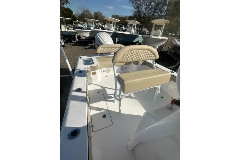 Slide: The Image of 2026 Delta Boatworks Delta D245 with beige seating, docked among other boats. - 13