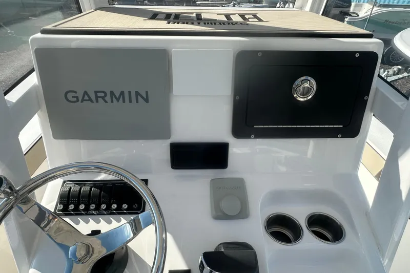 Slide: The Image of Delta D245 boat dashboard featuring Garmin navigation system, steering wheel, and control panel, 2026 model. - 16