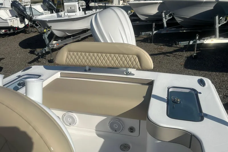 Slide: The Image of 2026 Delta D245 boat interior with beige seating and storage compartments, displayed outdoors. - 18
