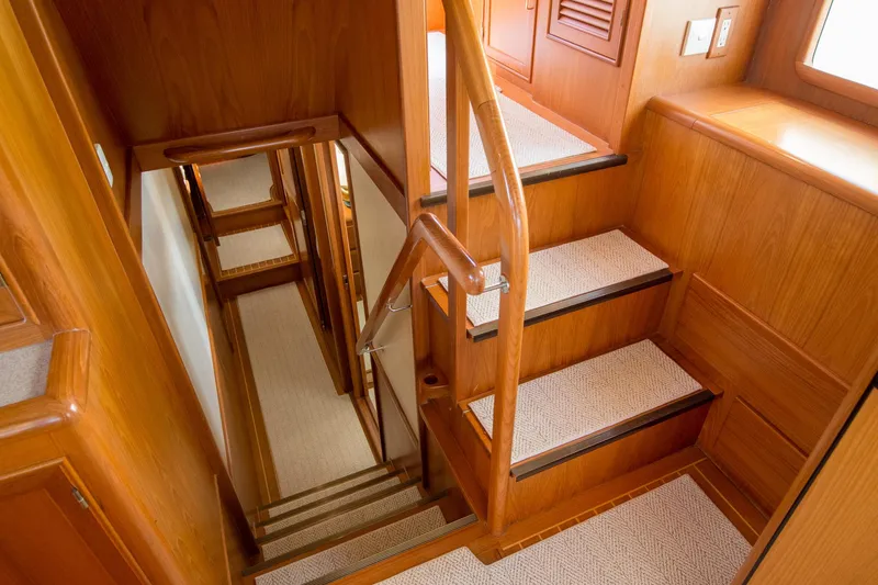 Slide: The Image of Wooden staircase inside a 2000 Fleming 55 yacht, featuring carpeted steps and elegant design. - 10