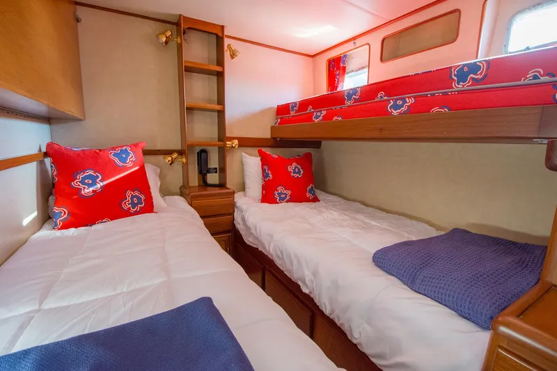 Slide: The Image of Cozy cabin interior of 2000 Fleming 55 yacht with twin beds and vibrant decor. - 13