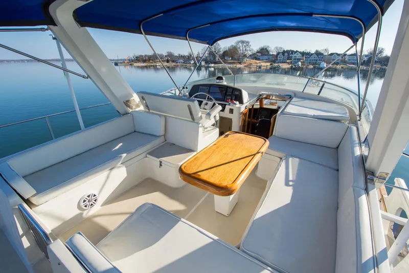 Slide: The Image of Luxurious 2000 Fleming 55 yacht interior with seating and table, overlooking serene waters. - 27
