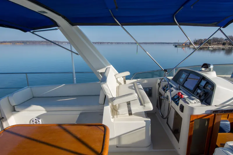 Slide: The Image of Helm of 2000 Fleming 55 yacht with blue canopy and serene water view. - 28