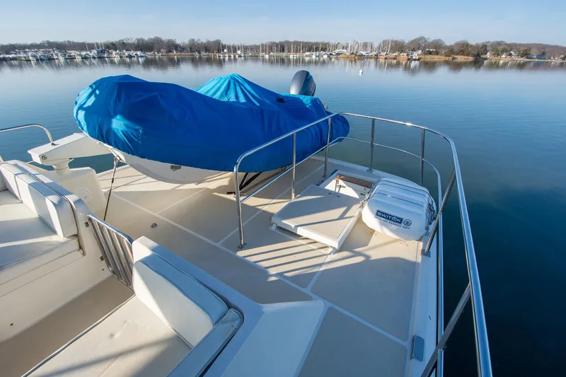 Slide: The Image of Deck of 2000 Fleming 55 yacht with covered equipment, calm water, and distant shoreline. - 34