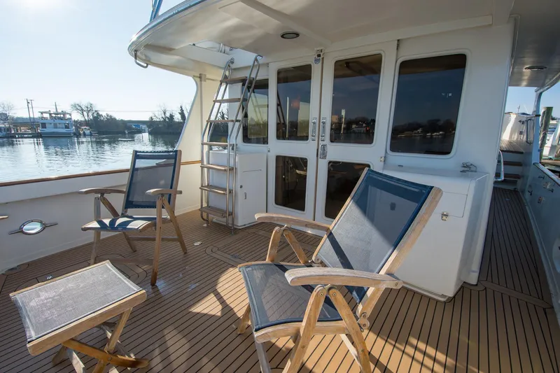 Slide: The Image of Deck of 2000 Fleming 55 yacht with chairs and table, overlooking calm waters. - 36